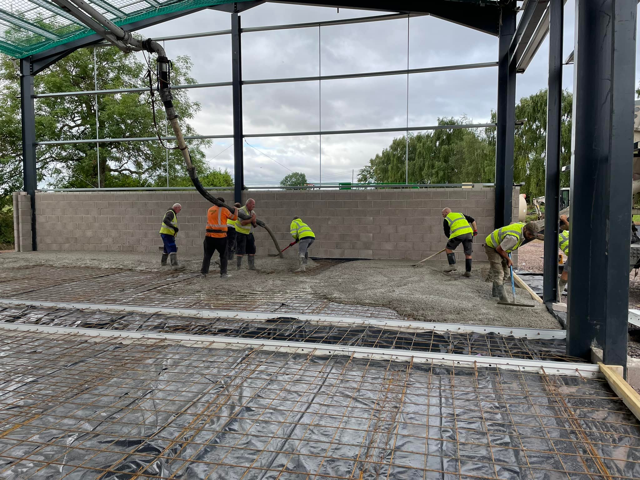 Concrete floor installation inside new steel-frame building by W.E. Phillips & Sons in Devon